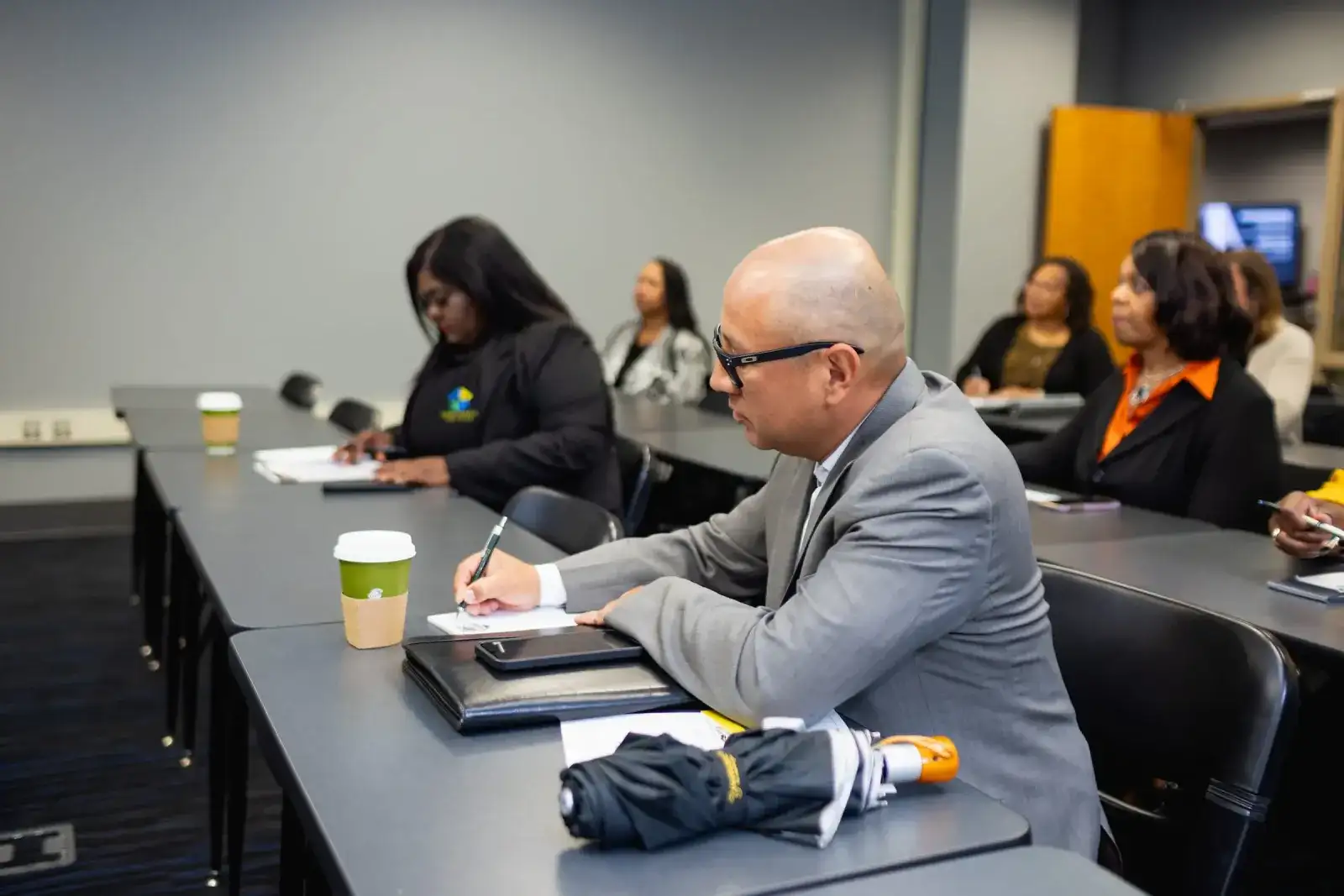 Participants taking notes during a caseworker training session