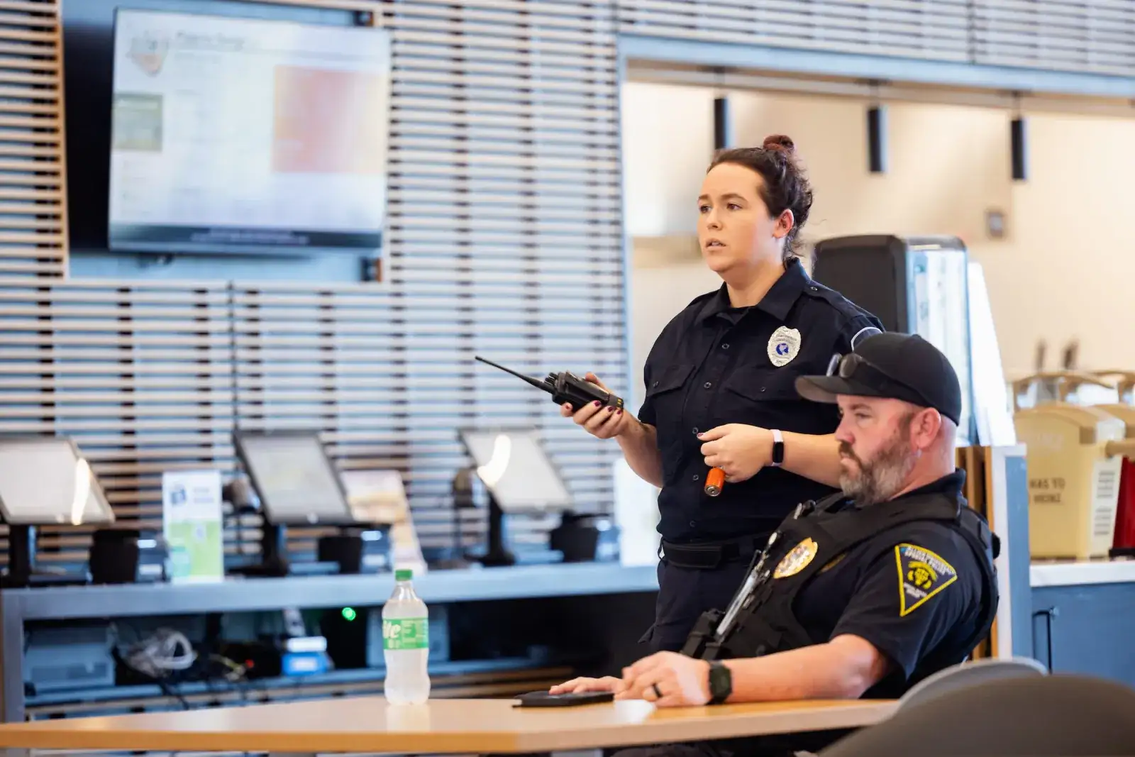 Criminal justice students at a dispatch console with radios and monitors