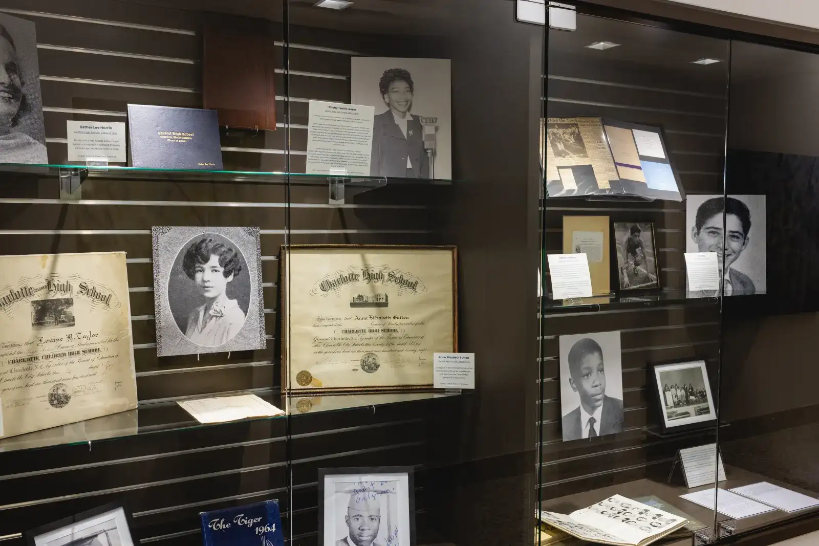 Artifacts and photos from the history of Central Piedmont on display behind glass.