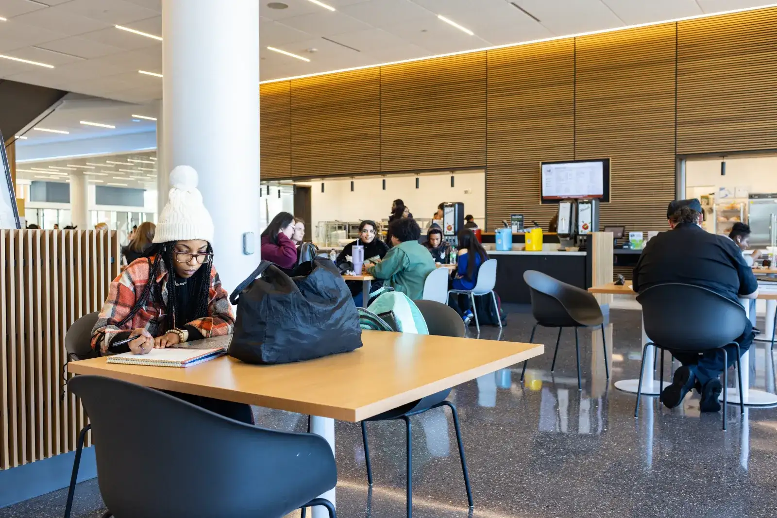 Students at multiple tables in Parr Center common area next to the dining options