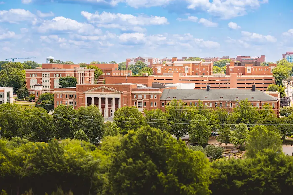 Central campus buildings foregrounded by leafy trees