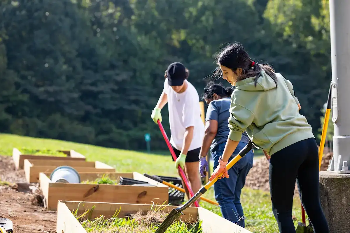 Student using a shovel in a raised bed