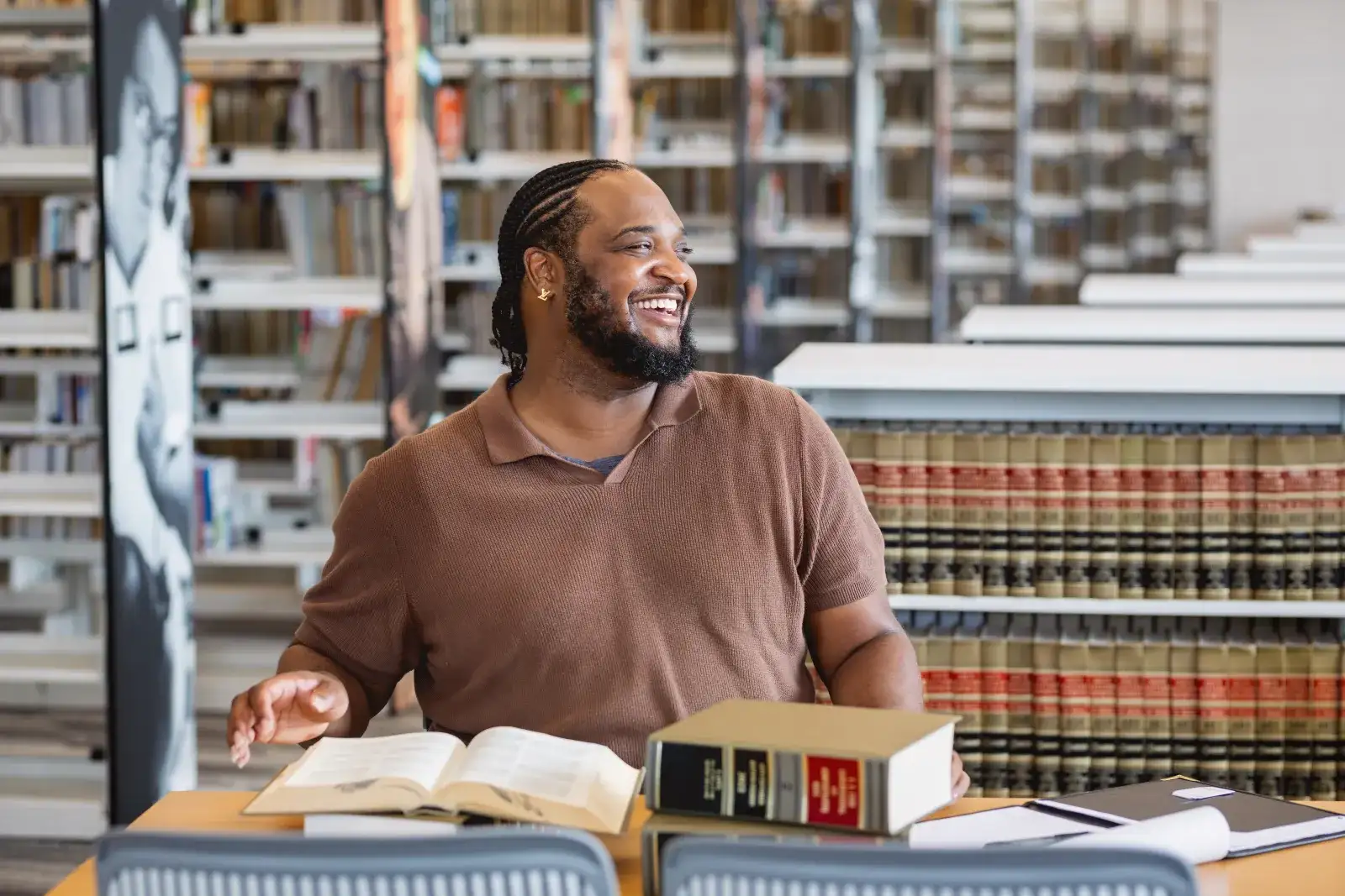 Student with wide smile while reviewing legal books