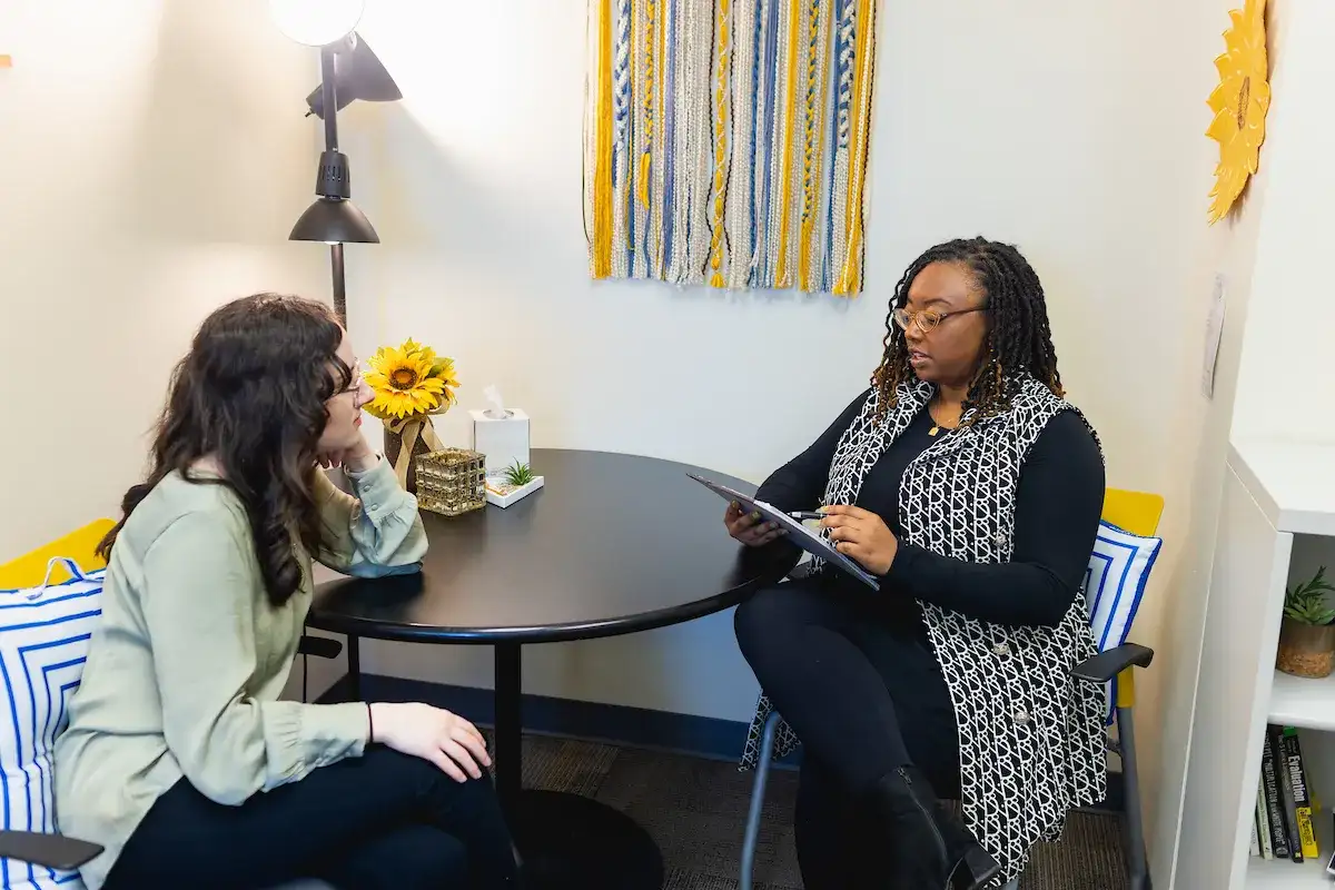 Student seated at a table with a Central Piedmont counselor