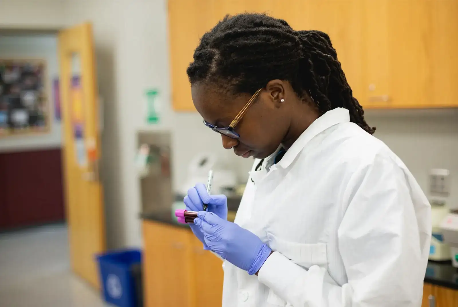 A Central Piedmont student labeling a collection tube in the lab