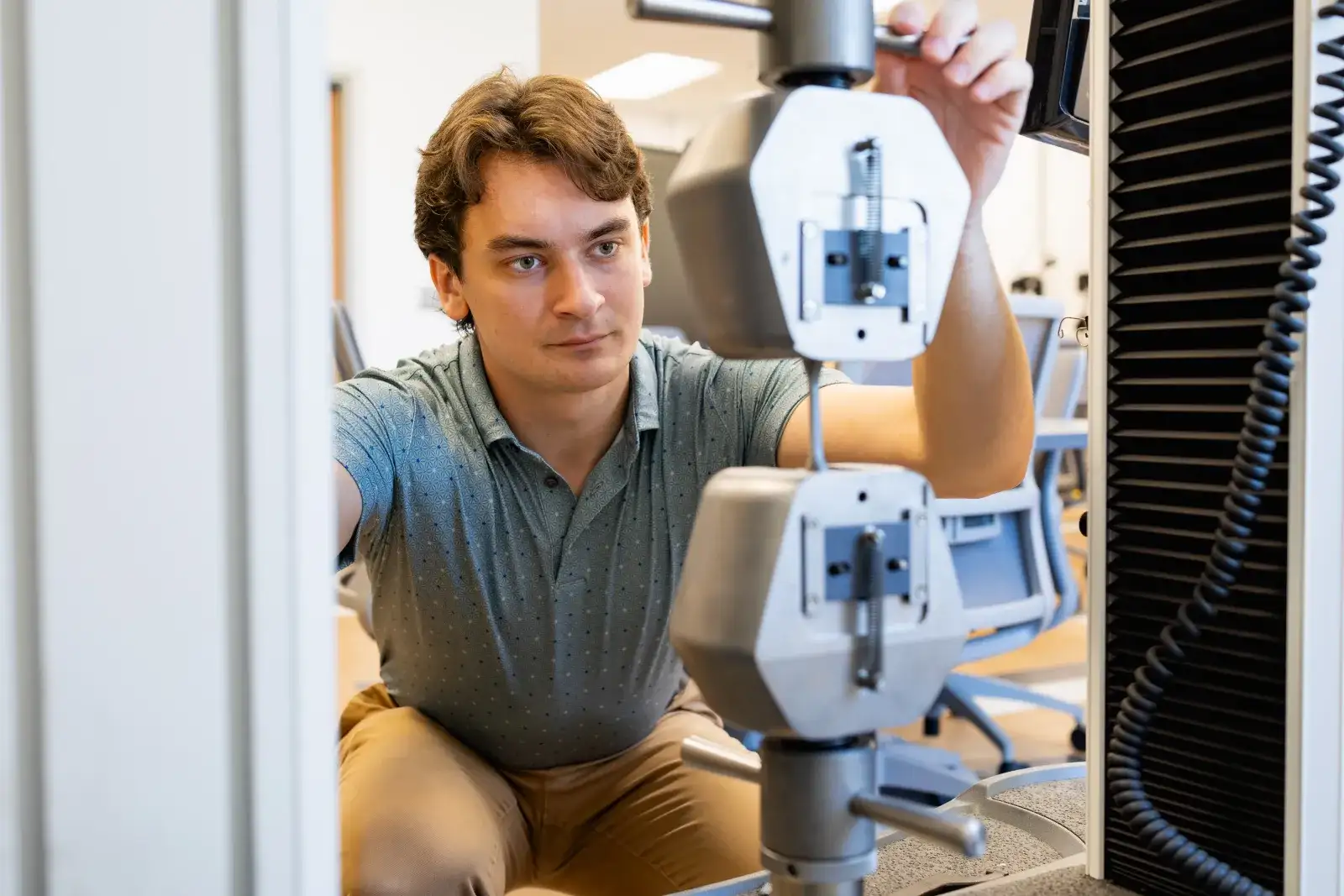 A person is operating a precision measurement device in a laboratory setting.