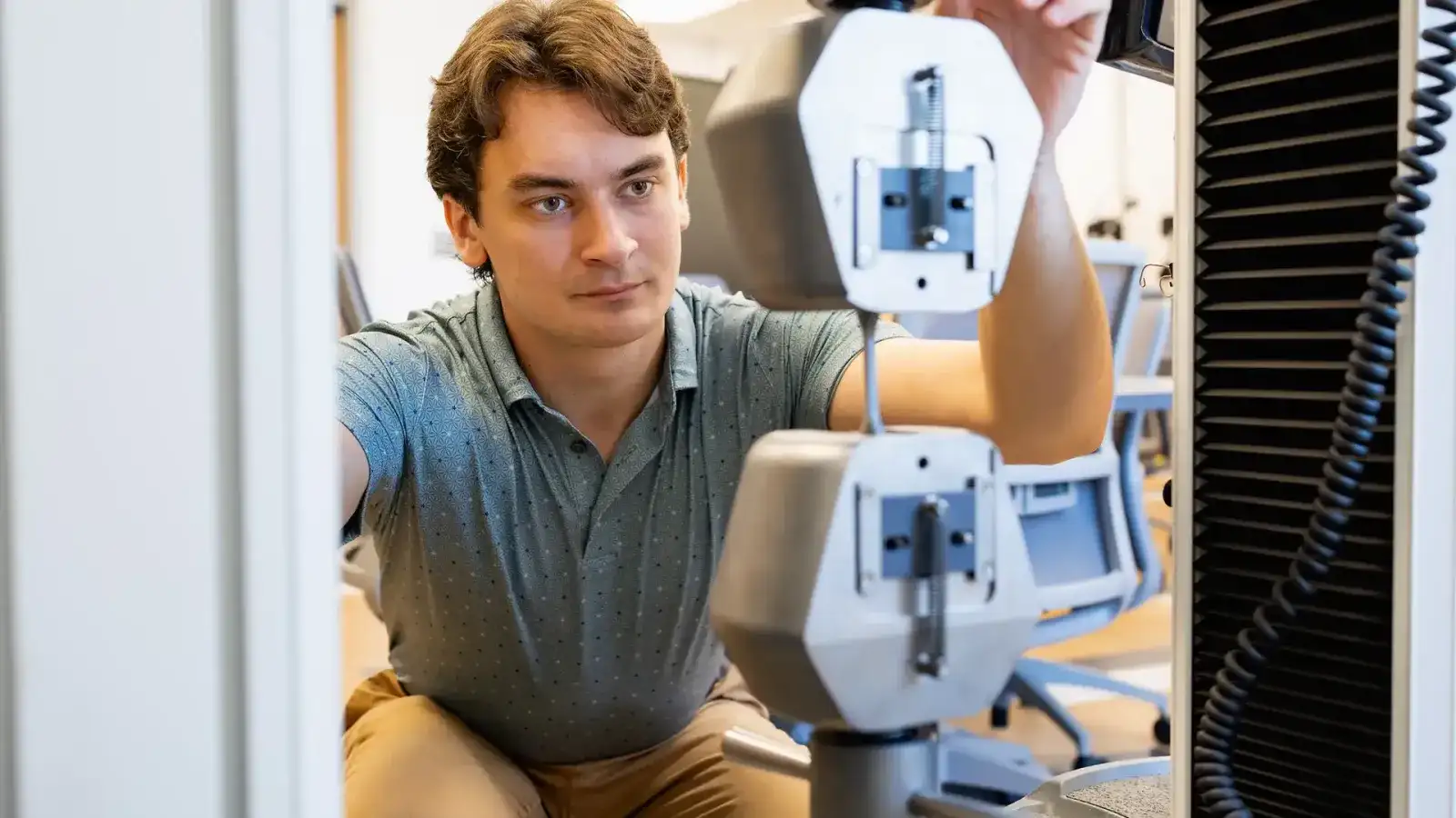A person is operating a precision measurement device in a laboratory setting.