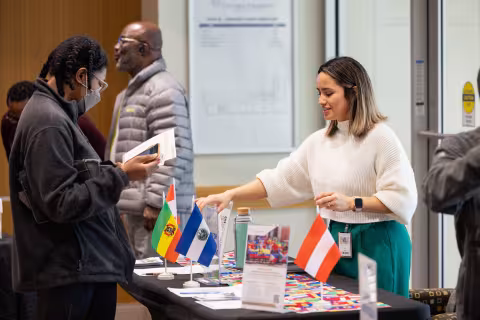 Students at an information table displaying flags of different countries