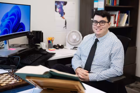 Instructor at a desk in an office lined with books