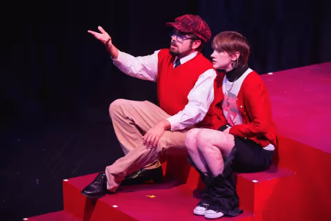 Two student actors in costume performing on stage