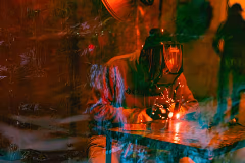 Sparks flying from a welding torch in a darkened workshop