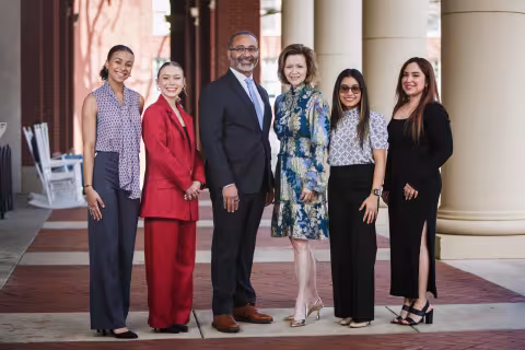Kandi Deitemeyer standing in a group of professionals outside a building with pillars