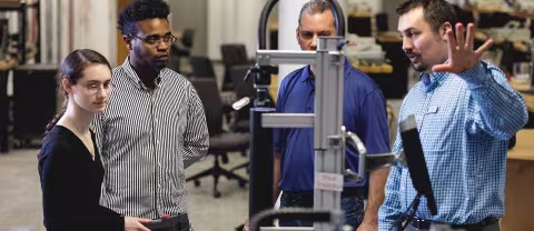 Instructor demonstrating test equipment to mechanical engineering students