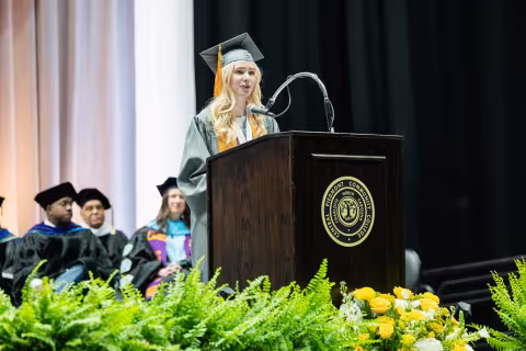 Graduate speaking at the commencement lectern