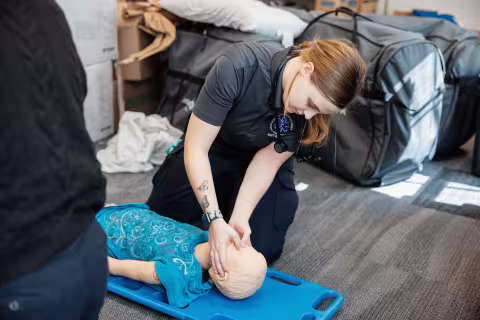 Emergency medical student assessing a training dummy